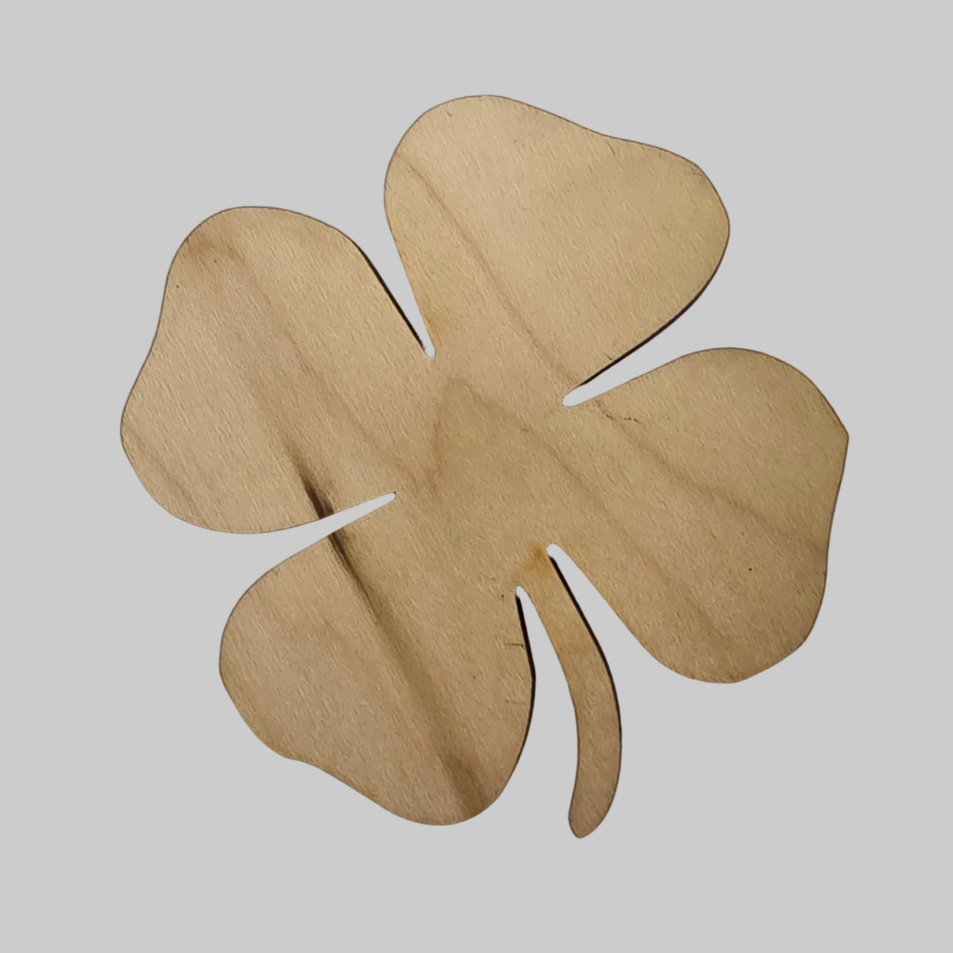 Wooden four-leaf clover cutout on a light gray background