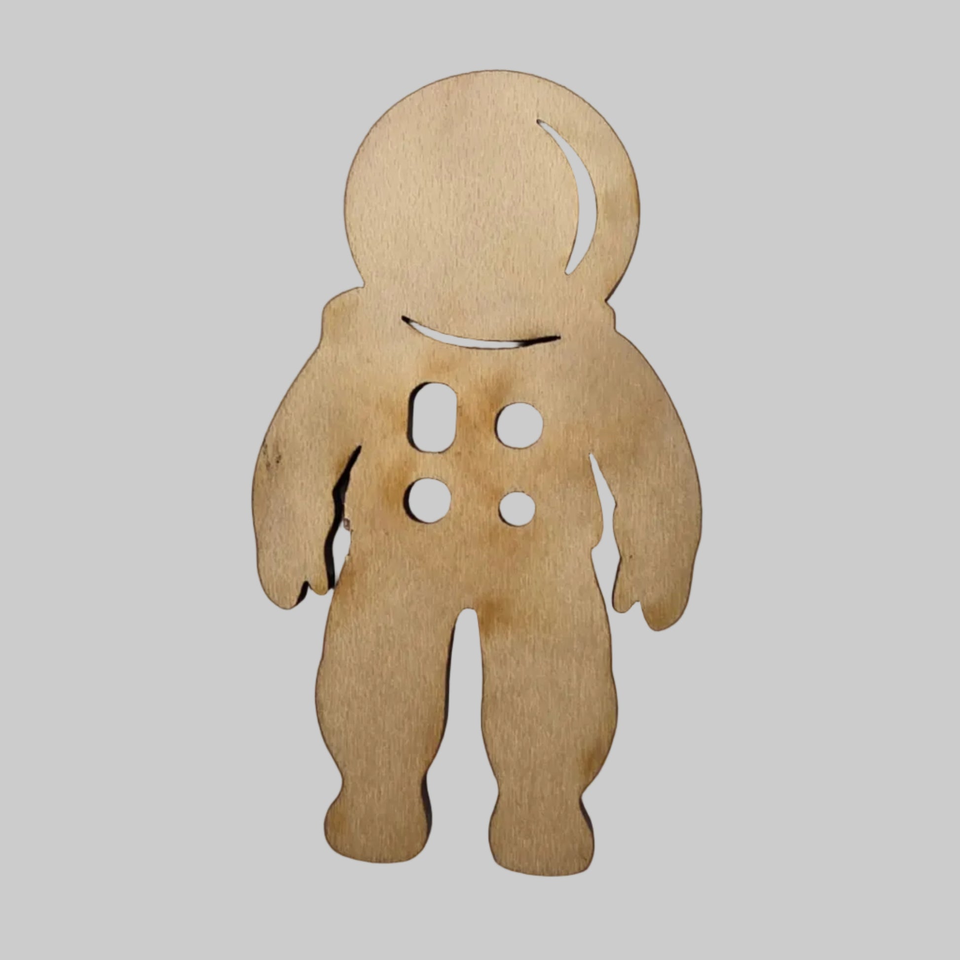Wooden cut out piece shaped like a astronaut on a white background