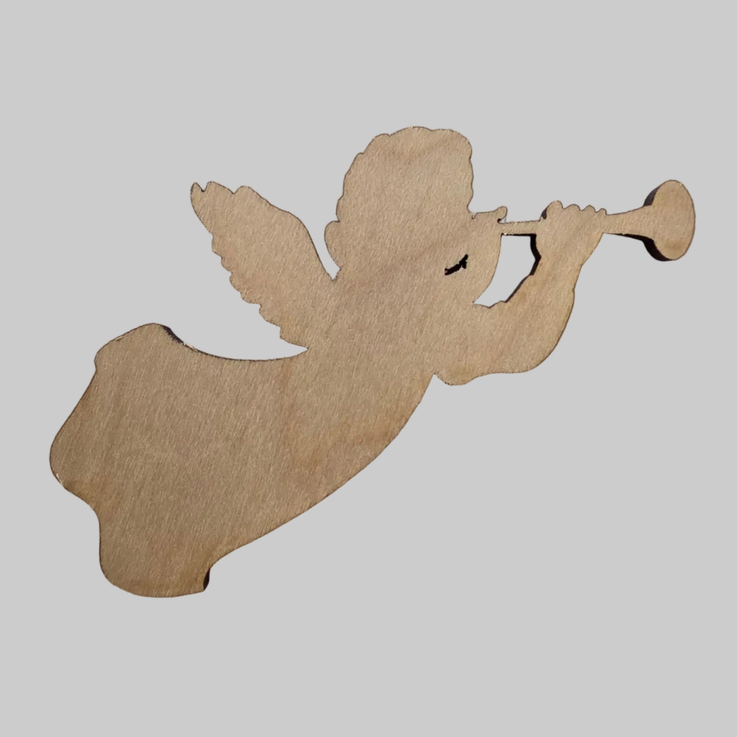 Wooden cutout of an angel holding a trumpet on a white background