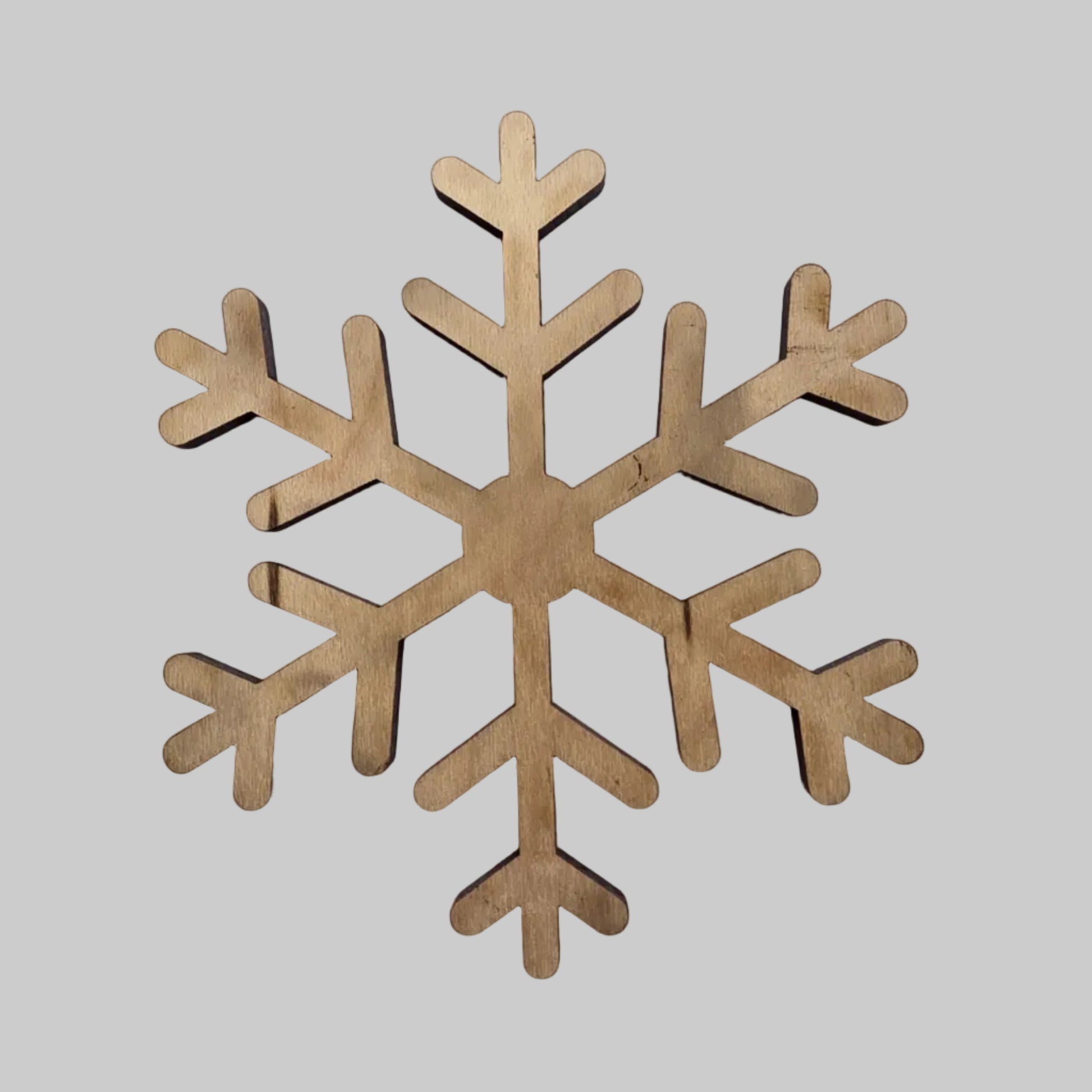Wooden snowflake decoration on a light gray background