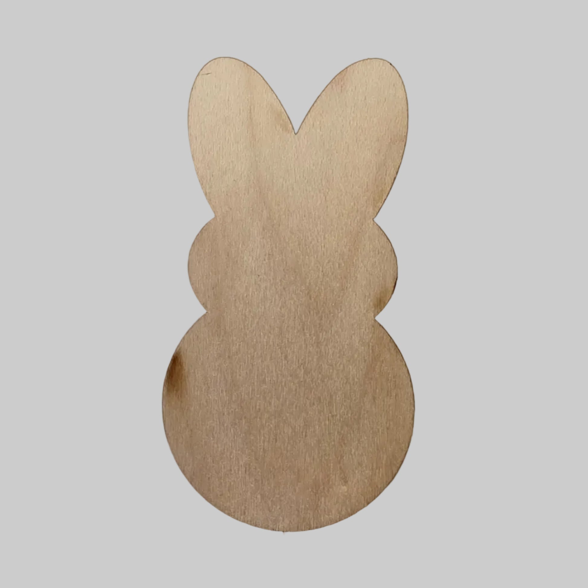 Wooden candy bunny-shaped cutout on a white background.