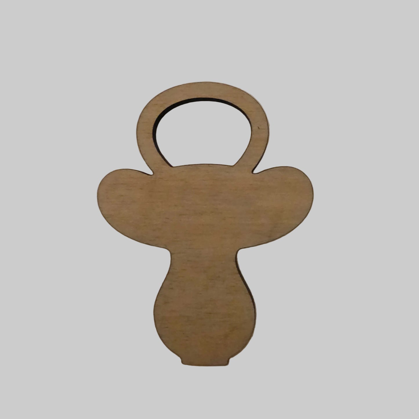 Wooden pacifier shape on a beige background