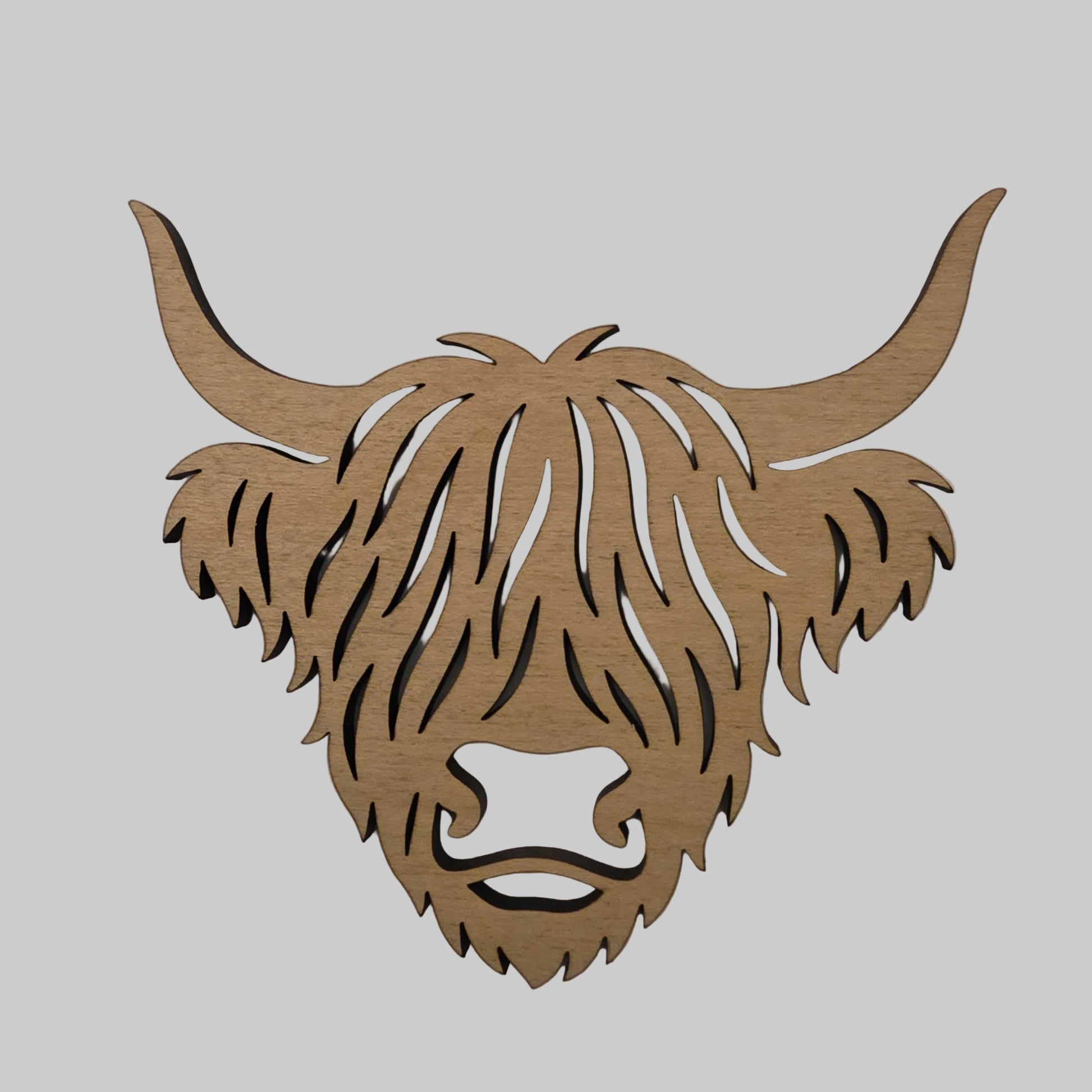 Wooden cutout of a highland cow head on a plain background
