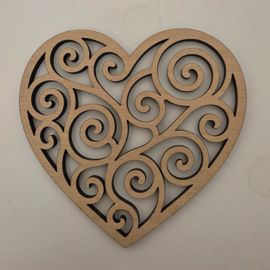 Decorative wooden heart with intricate spiral patterns on a plain background