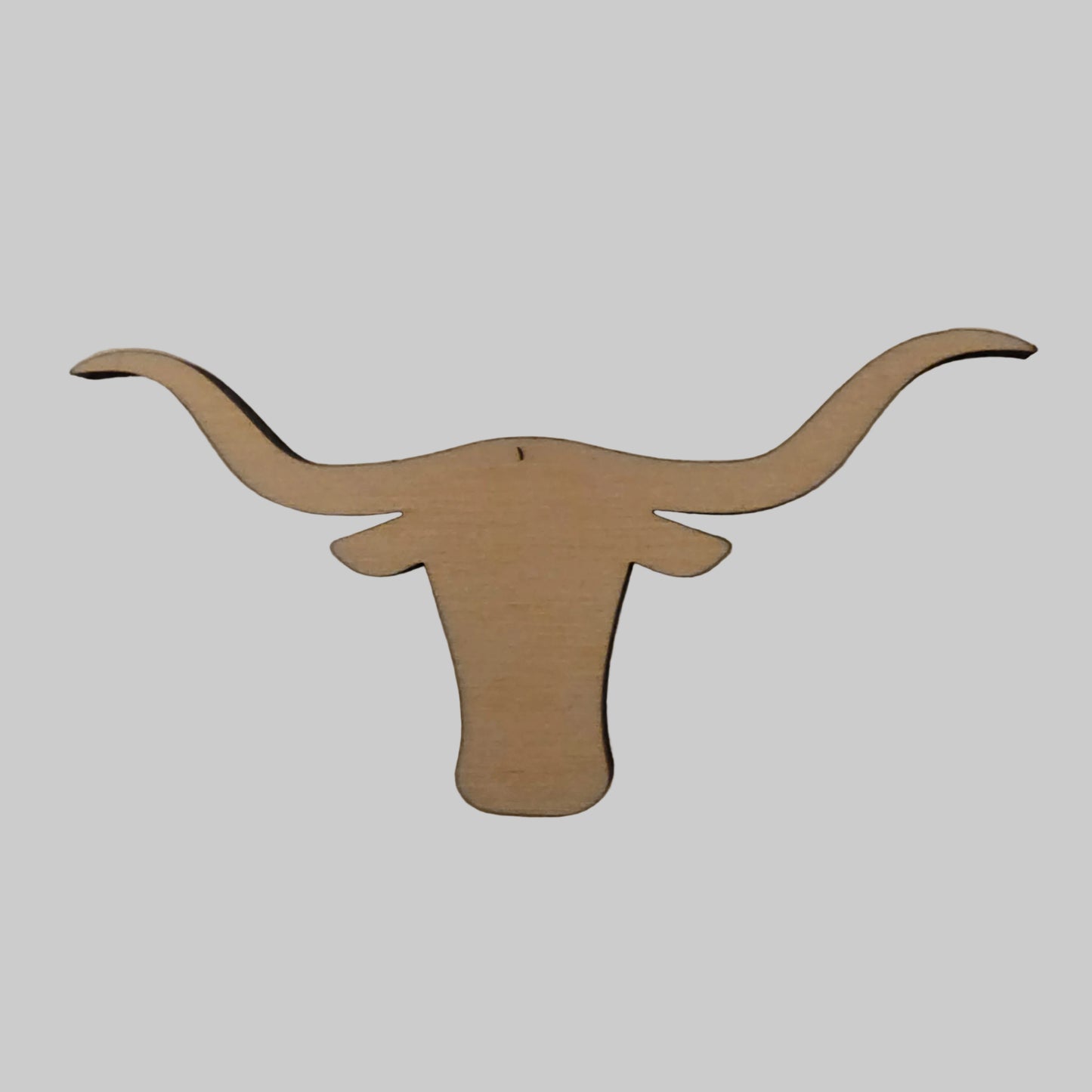 Wooden longhorn head cutout on a plain background