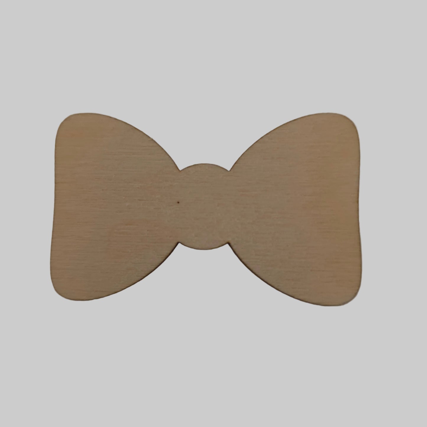 Wooden bow tie shape on a beige background
