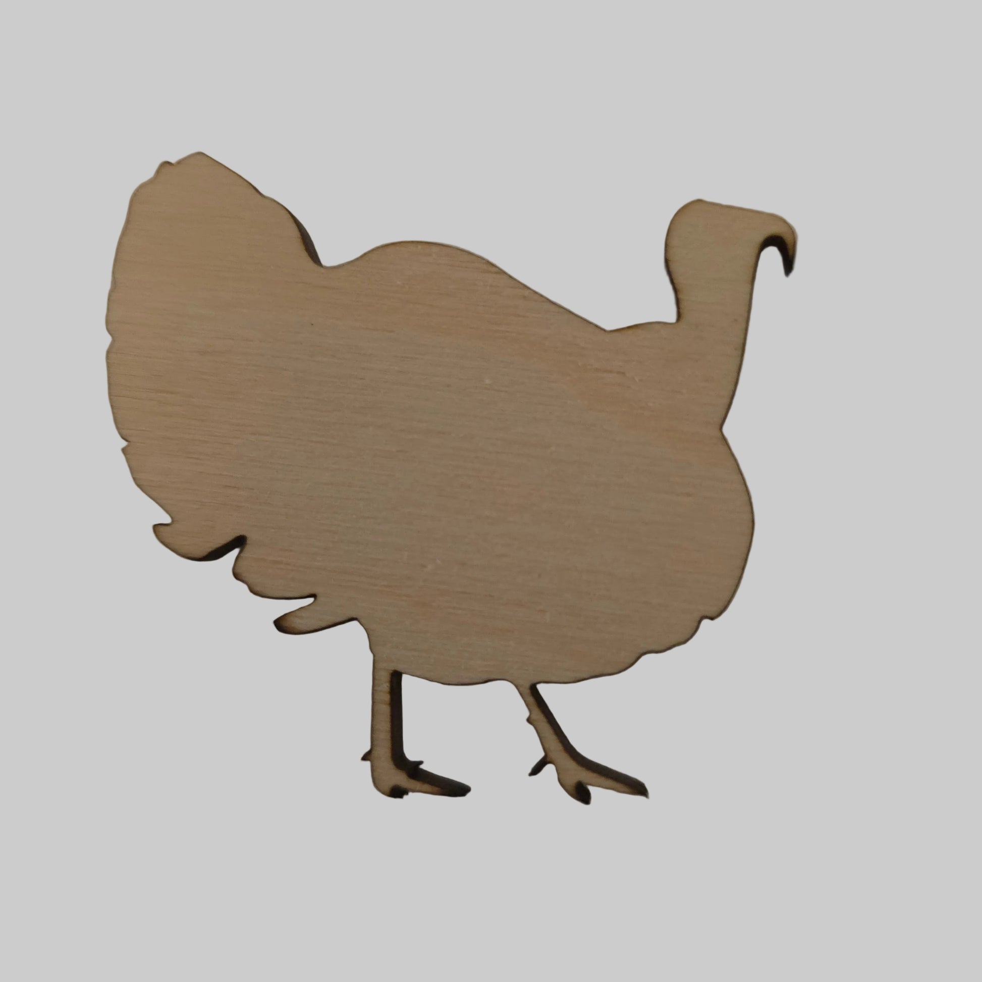 Wooden cutout of a turkey shape on a plain background