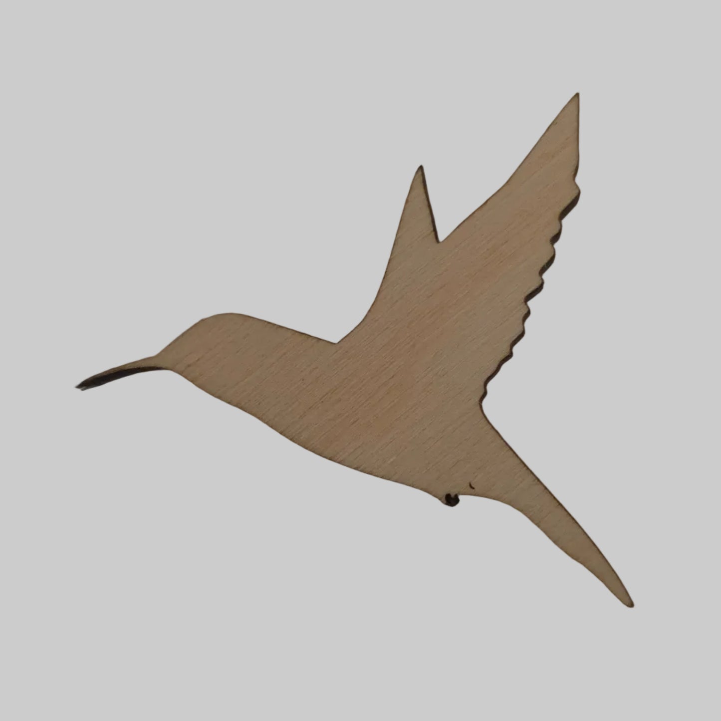 Wooden hummingbird cutout on a beige background