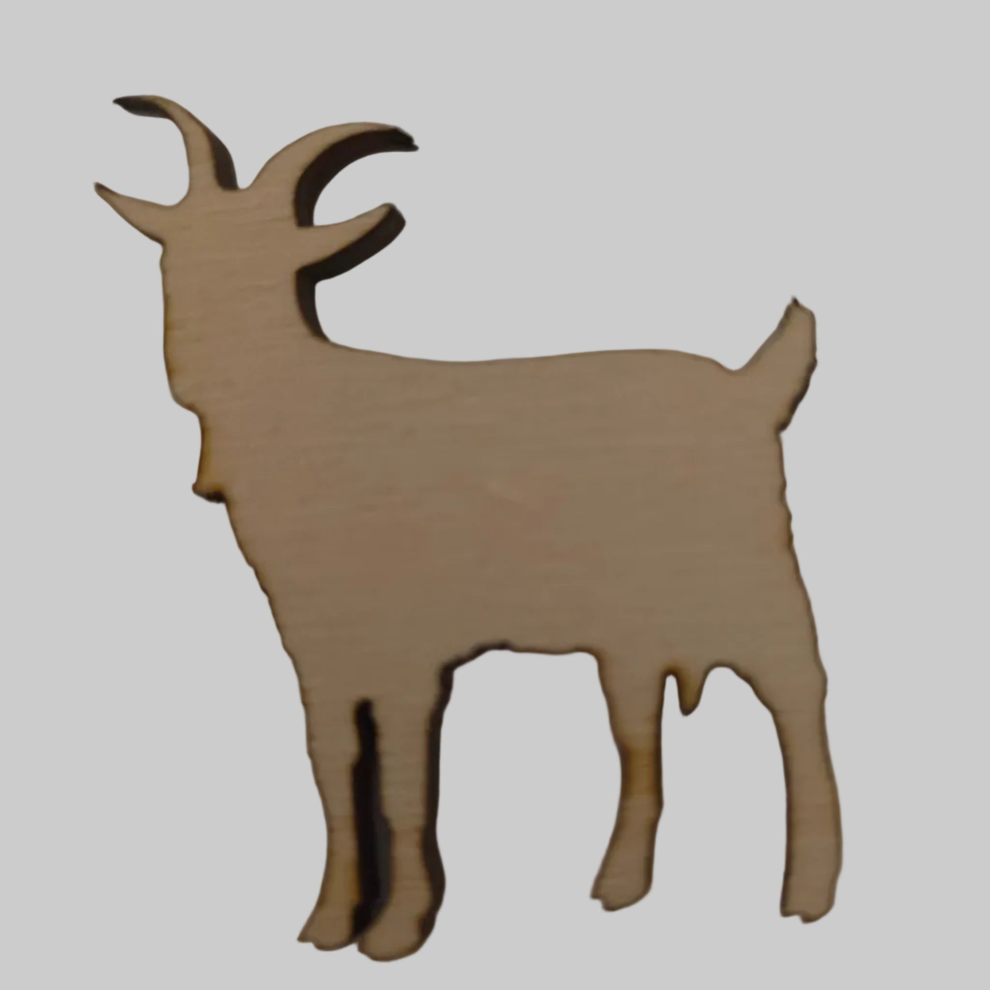 Wooden cutout of a billie goat shape on a plain background