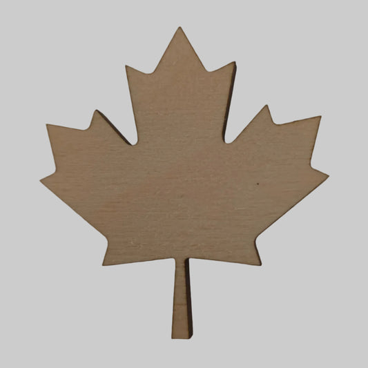 Wooden maple leaf-shaped cutout on a beige background