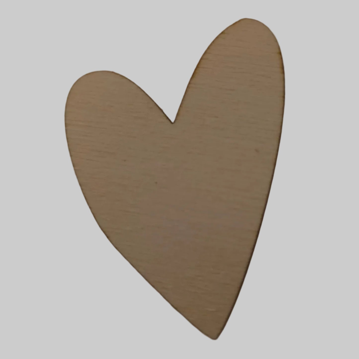 Wooden heart-shaped object on a light beige background
