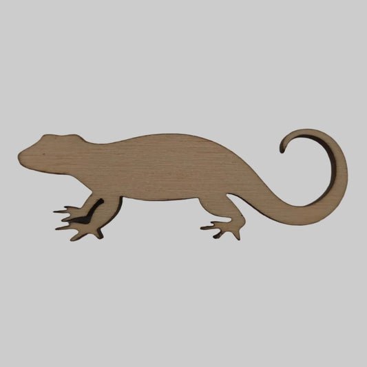 Wooden lizard-shaped ornament on a beige background