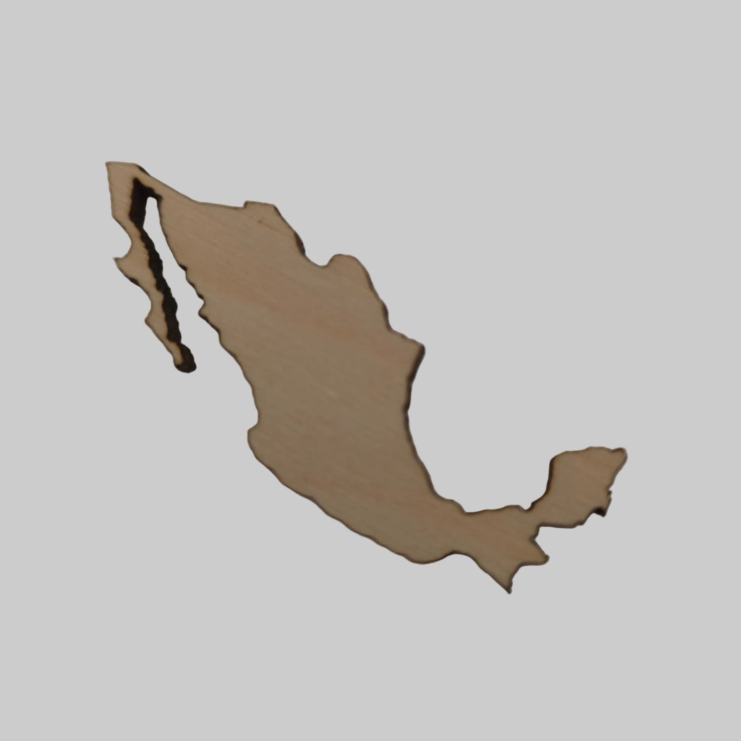 Wooden cutout of a map shape of Mexico  on a beige background