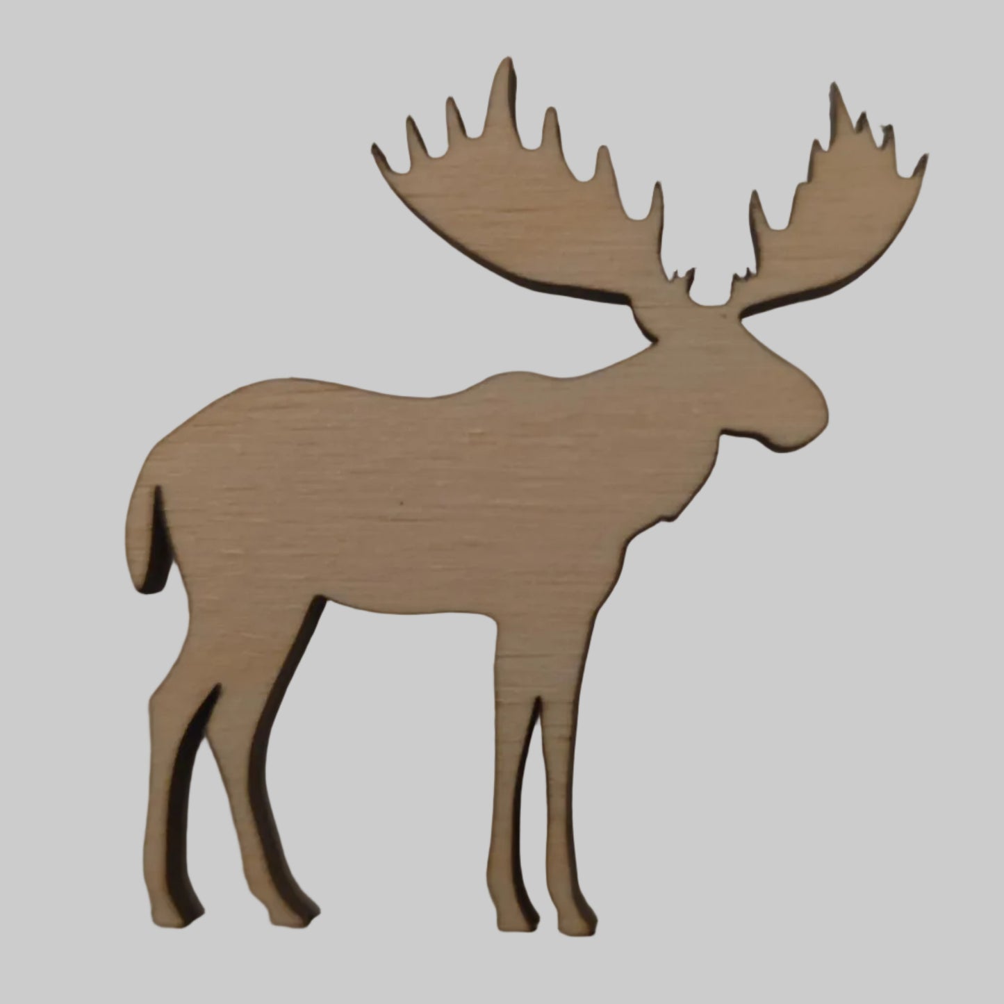 Wooden cutout of a moose on a plain background