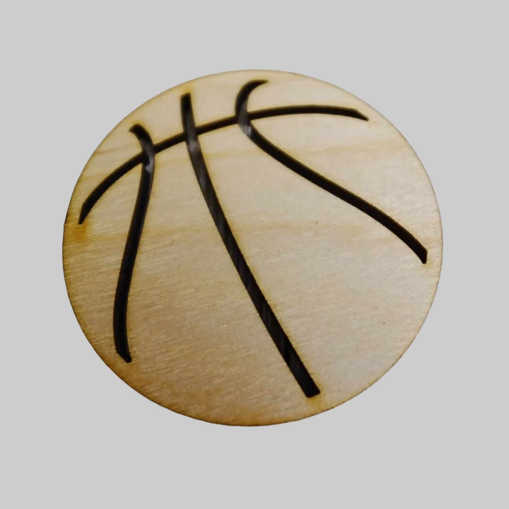 Wooden basketball-shaped object with black lines on a wooden surface